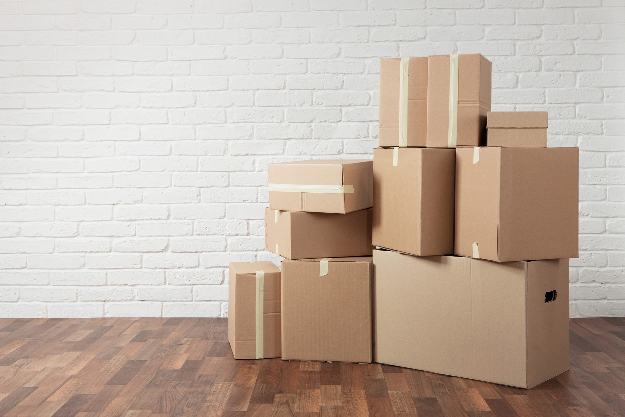 Moving in. Stack of cardboard boxes in the empty room with copy space